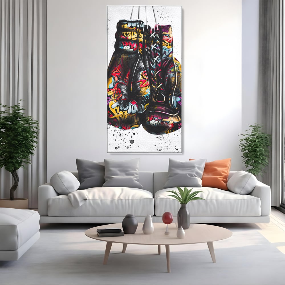 Tablou canvas cu tablou canvas cu manusi de box, in rama de aluminiu argintiu, pe perete intr-un living